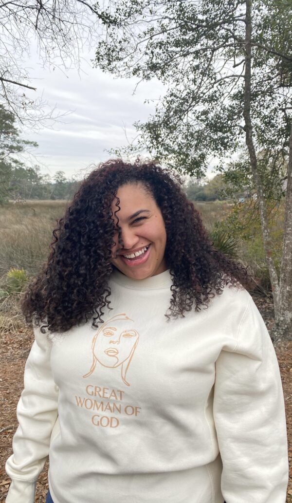 A woman wearing a Great Woman of God sweatshirt